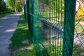 Metal fence painted in green color.Metal wire grating along the playground in the park Royalty Free Stock Photo