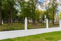 Metal fence with white concrete pillars in the city Park. Autumn day Royalty Free Stock Photo