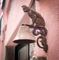 Metal figure of cat as decoration of bell carried on a wall