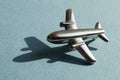 Metal figure of small airplane on the turqouise and light blue geometry background. Conceptual trendy photo of aircraft