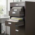 A metal filing cabinet with multiple open drawers, filled with organized folders.