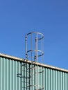 Metal fire escape on the roof of an industrial building against the blue sky. Safety of the work of people. Evacuation during Royalty Free Stock Photo