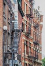 Metal fire escape stairs hanging from side of old brick apartment building Royalty Free Stock Photo