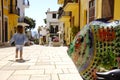 Metal fish in foreground for sale in front of a store. in the background a little girl seen from behind. Royalty Free Stock Photo