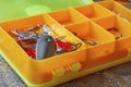 Metal fishing baits in a orange plastic storage box closeup Royalty Free Stock Photo