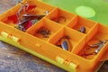 Metal fishing baits in a orange plastic storage box closeup Royalty Free Stock Photo