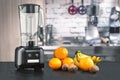 Metal food blender close-up with fresh exotic tropic fruits next to it on kitchen background with empty space