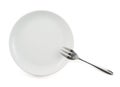 Metal fork in a ceramic plate isolated Royalty Free Stock Photo