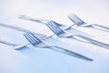 . Metal forks with shadows isolated on a white table. Royalty Free Stock Photo