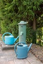 Metal fountain and plastic watering can