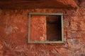 METAL FRAME AROUND AN OPENING IN THE WALL OF AN OLD FORT IN RUINS