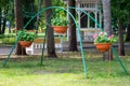 Metal frame for hanging pots with flowers in the park Royalty Free Stock Photo