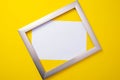 Metal frame with a white background lies on a yellow background