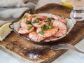 Metal frying pan with prawns fried with herbs and garlic on an old board Royalty Free Stock Photo