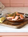 Metal frying pan with prawns fried with herbs and garlic on an old board Royalty Free Stock Photo