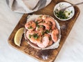 Metal frying pan with prawns fried with herbs and garlic on an old board Royalty Free Stock Photo