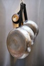 Metal frying pans hanging on a rack in an industrial restaurant kitchen