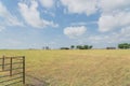 Metal gate leads to large prairie and Texas farm house with storage tower silo in farmyard Royalty Free Stock Photo