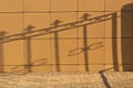 Metal gate shadow on orange wall. Royalty Free Stock Photo