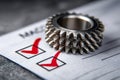 Metal gears placed on a checklist paper with red check marks symbolizing precision, quality control, and mechanical engineering Royalty Free Stock Photo