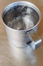 Metal glass or cup of cold water with ice on stainless steel tab Royalty Free Stock Photo