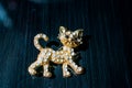 Metal Golden brooch in the form of a kitten or a tiger cub with white stones, rhinestones. On a black glossy, reflective backgroun Royalty Free Stock Photo