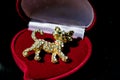 Metal Golden brooch in the form of a kitten or a tiger cub with white stones, rhinestones. On a black glossy, reflective backgroun Royalty Free Stock Photo