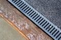 Metal grate of rainwater drainage system on a sidewalk Royalty Free Stock Photo