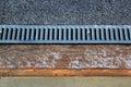 Metal grate of rainwater drainage system on a sidewalk Royalty Free Stock Photo