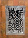 Metal grating with patterns on the wall of the house