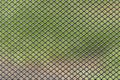 Metal grid with blurred green brown background