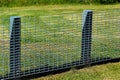 Metal grid fence on a green lawn
