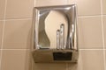 Metal hand dryer on the tiled wall. Hot air for drying hands on the wall with tiles. Drier in public toilet after washing