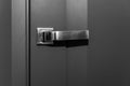 Metal handle on a stylish gray door. Close-up. Modern trends in decorating and interior design