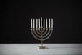 Metal Hanukkah Menorah With Unlit Candles On Marble Surface Against Black Studio Background