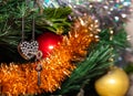 Metal heart shaped padlock with keys hanging on Christmas tree. Close up shot. Red, golden balls and white and golden tinsel Royalty Free Stock Photo