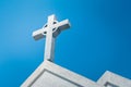 Metal holy cross or crucifix on the top of white church.