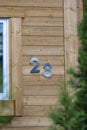 Metal house number 28 on a wooden wall background on the street in Austria Royalty Free Stock Photo