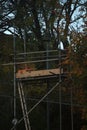 Metal hunting tower highseat surrounded by lush green trees Royalty Free Stock Photo