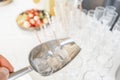 A metal ice bucket with full of crushed ice and stainless scoop for dessert on table in hotel. Royalty Free Stock Photo