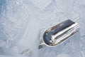 Metal ice scoop and plastic cup on the ice in bucket Royalty Free Stock Photo