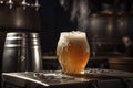 metal keg with foamy wave of beer and glass with frothy head in the background