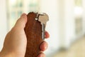Metal Key and Wooden Keychain in Male Hand Royalty Free Stock Photo
