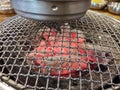 Metal Korean barbecue with red hot coals and chimney above