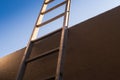Metal ladder against brown wall.