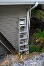 Metal ladder leaning up against the exterior of a residential house, home improvement project Royalty Free Stock Photo