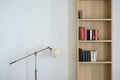 Metal lamp stand and wooden bookshelf with books Royalty Free Stock Photo