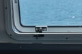 Metal latch on a ferry boat window on bright spring day Royalty Free Stock Photo