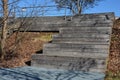 Metal lattice floor terrace under a wooden staircase that serves as a bench or auditorium yard in the park on the promenade. . squ