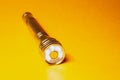 Metal led flashlight on a yellow background Royalty Free Stock Photo